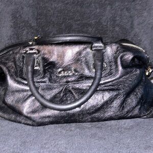 Black leather tote coach bag with a purple inside